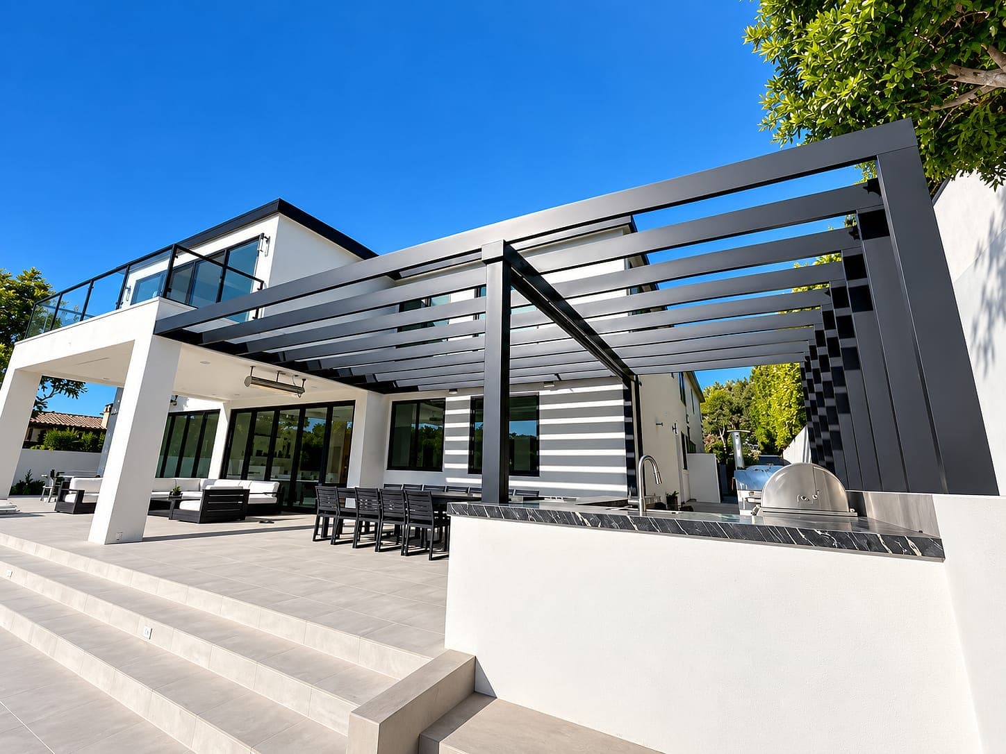 Aluminum slat trellis over an outdoor kitchen and dining terrace of a modern home.