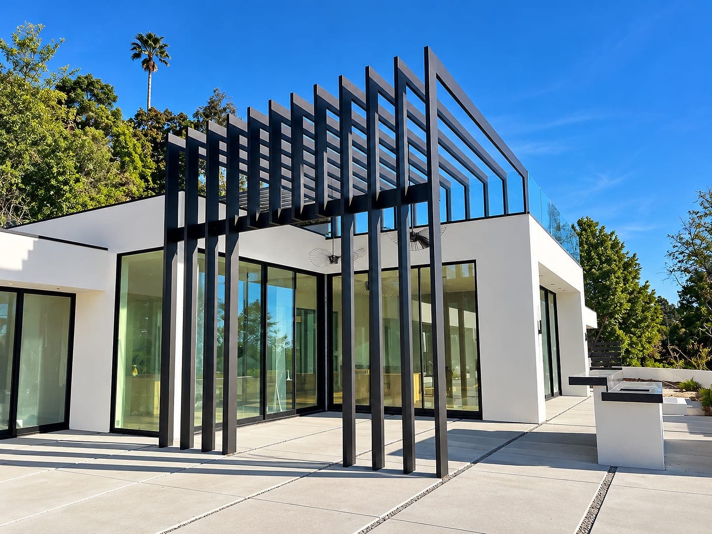 Tall aluminum slat frames along the glass front of a modern home.