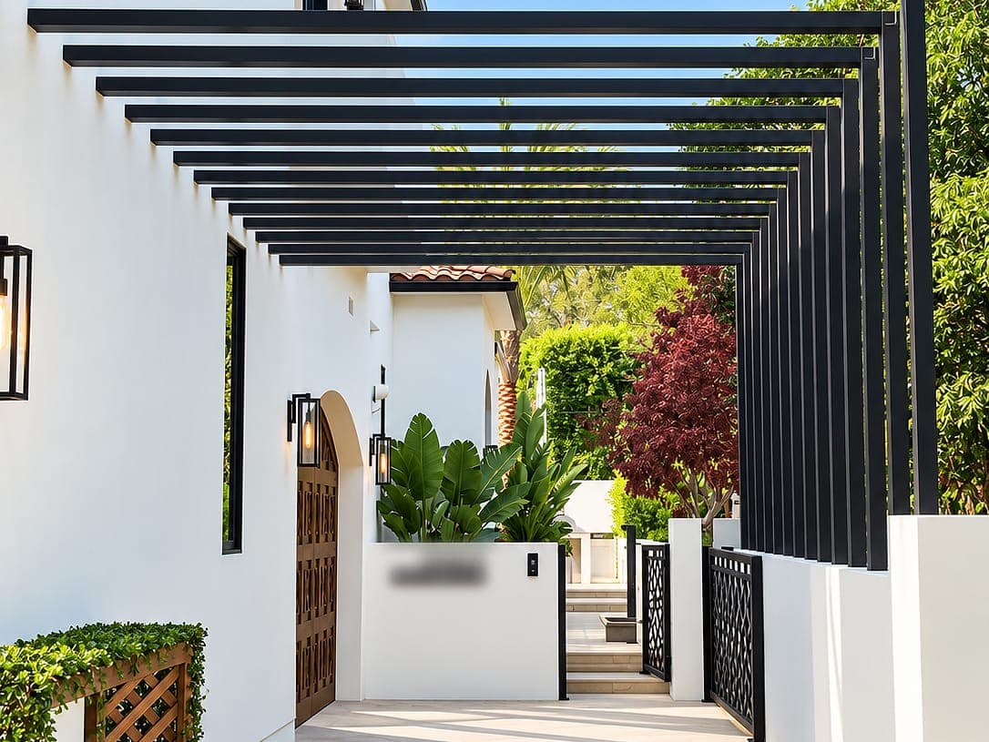 Aluminum slat trellis over an entry walkway beside a home.