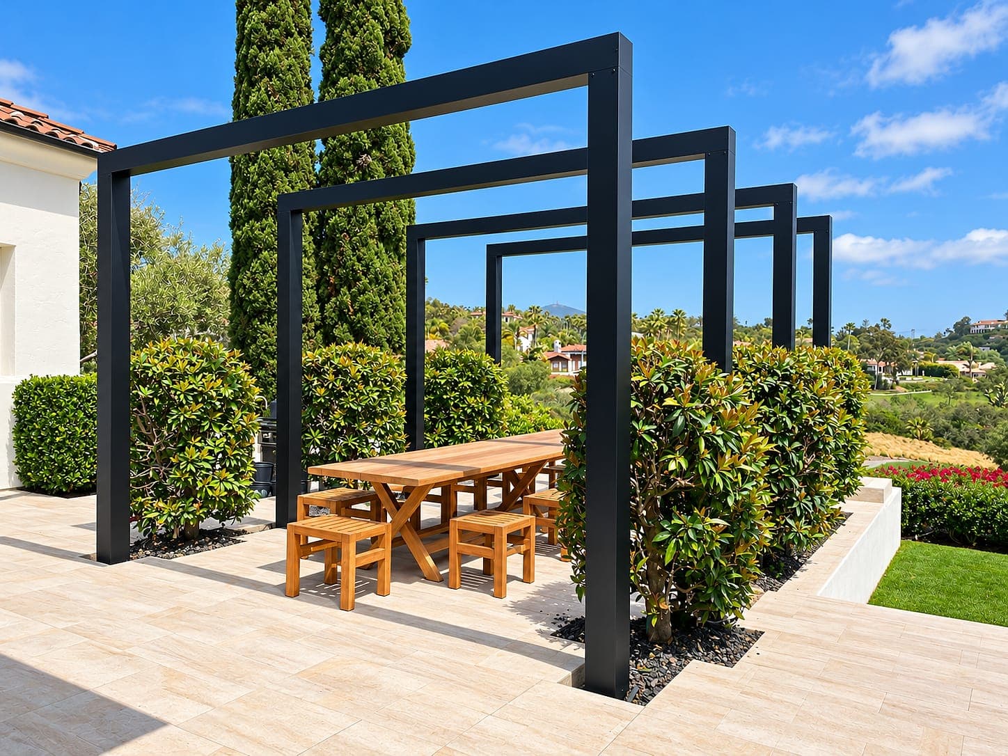Aluminum portal frames over a wooden outdoor dining table on a stone patio.