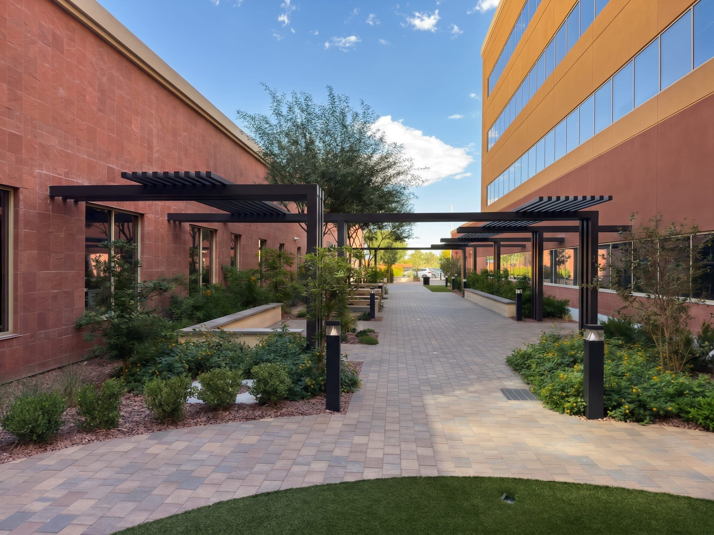 Espresso aluminum lattice-top architectural feature along a courtyard walkway at Southern Hills Hospital