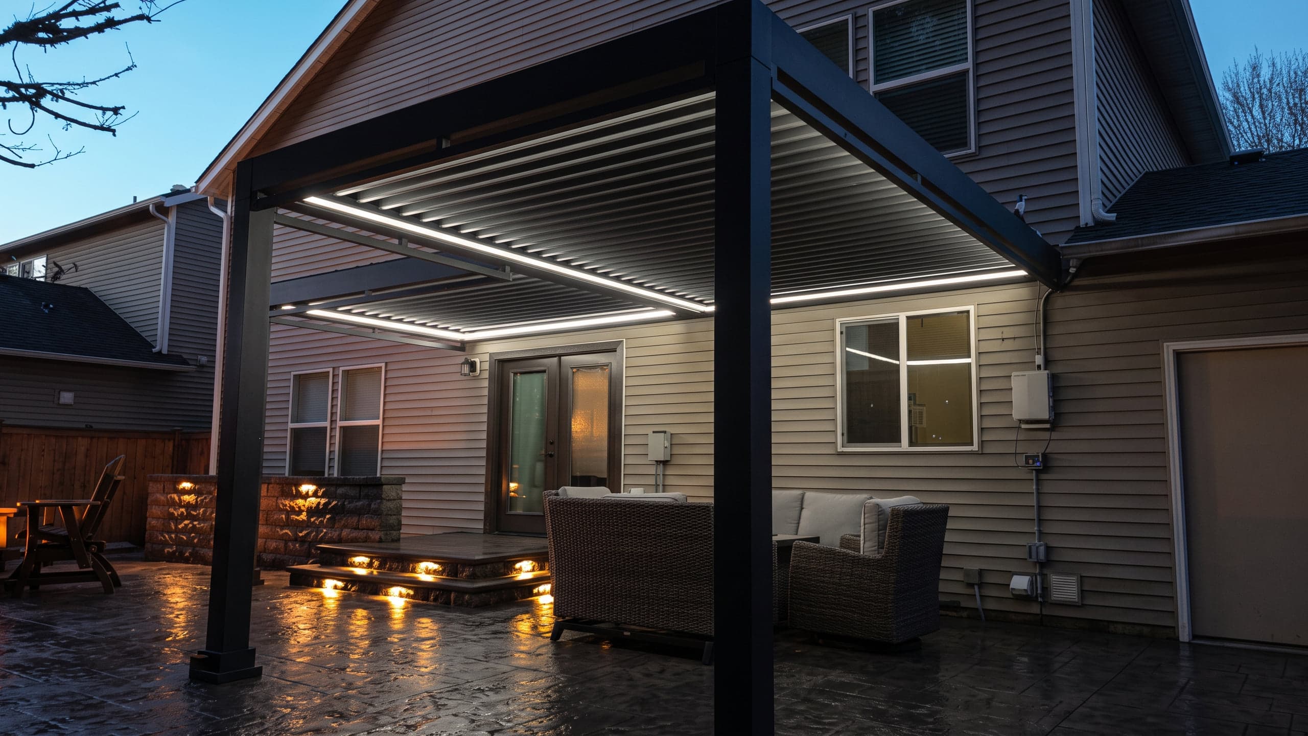 Louvered roof over a back patio at dusk, outlined with white LED strip lights.