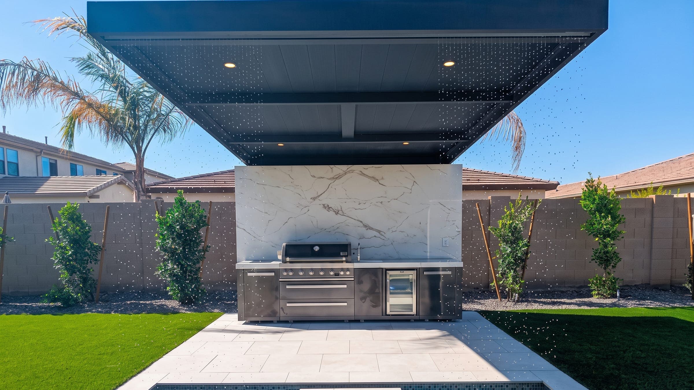 Black cantilever with a Twin Wall roof over an outdoor kitchen beside a pool